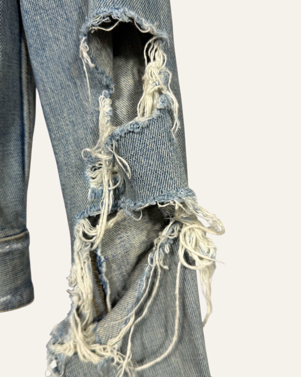 Saint Laurent light wash distressed denim fitted trucker jacket with ripped sleeves