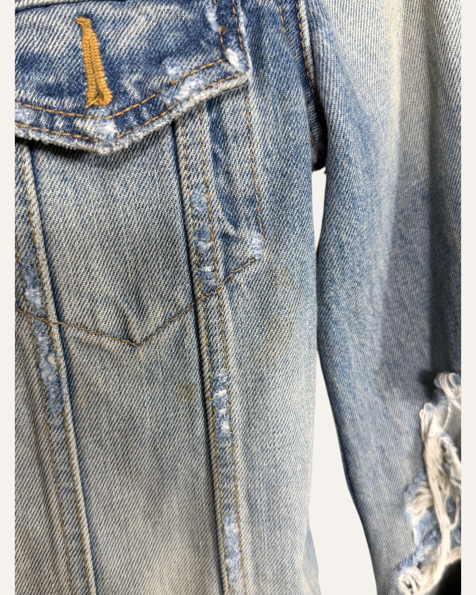 Saint Laurent light wash distressed denim fitted trucker jacket with ripped sleeves