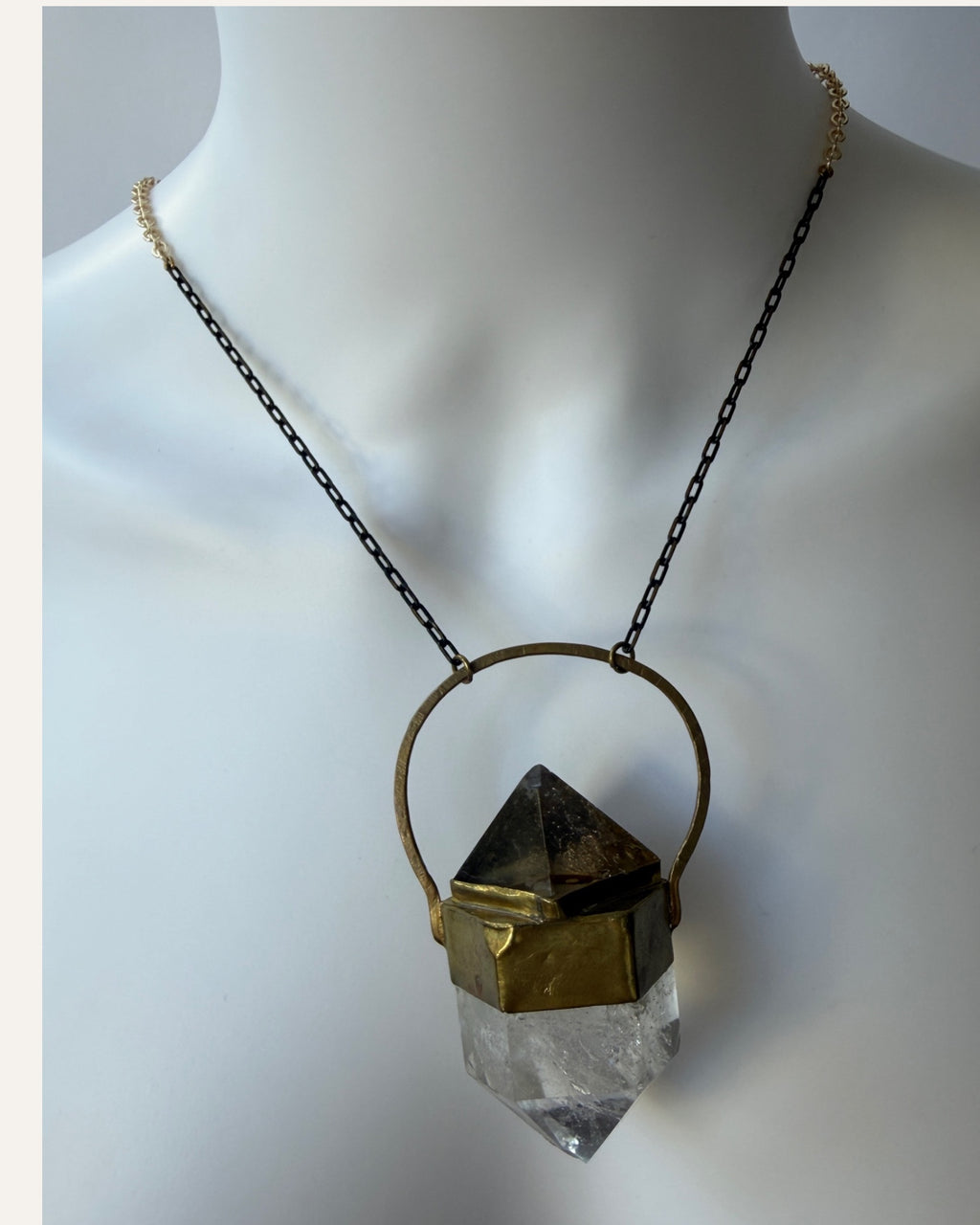 Sculptural crystal pendant necklace with gold-tone geometric setting and mixed metal chain