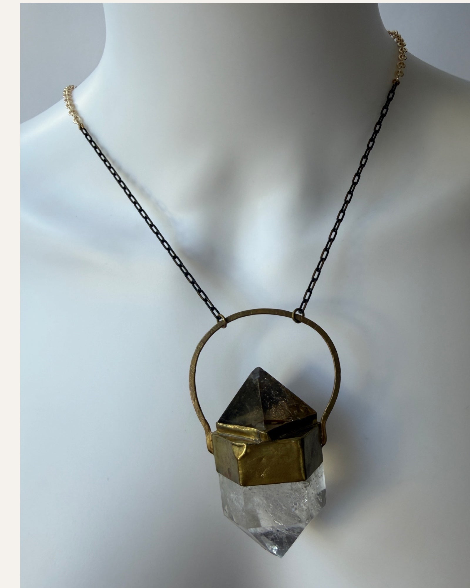 Sculptural crystal pendant necklace with gold-tone geometric setting and mixed metal chain