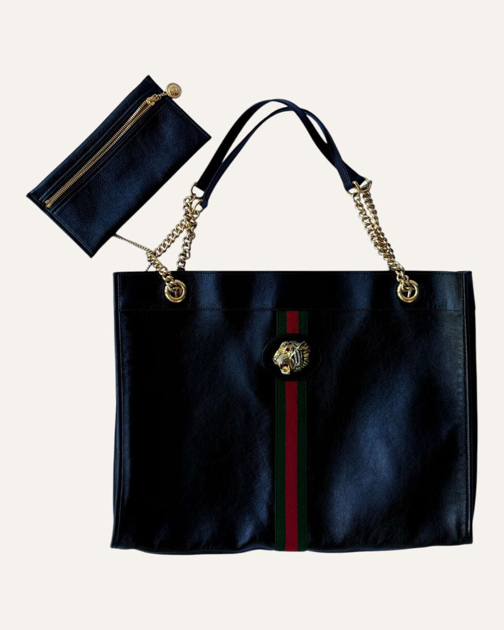 Gucci Rajah large black leather tote with gold chain straps, tiger head hardware, and matching zip pouch