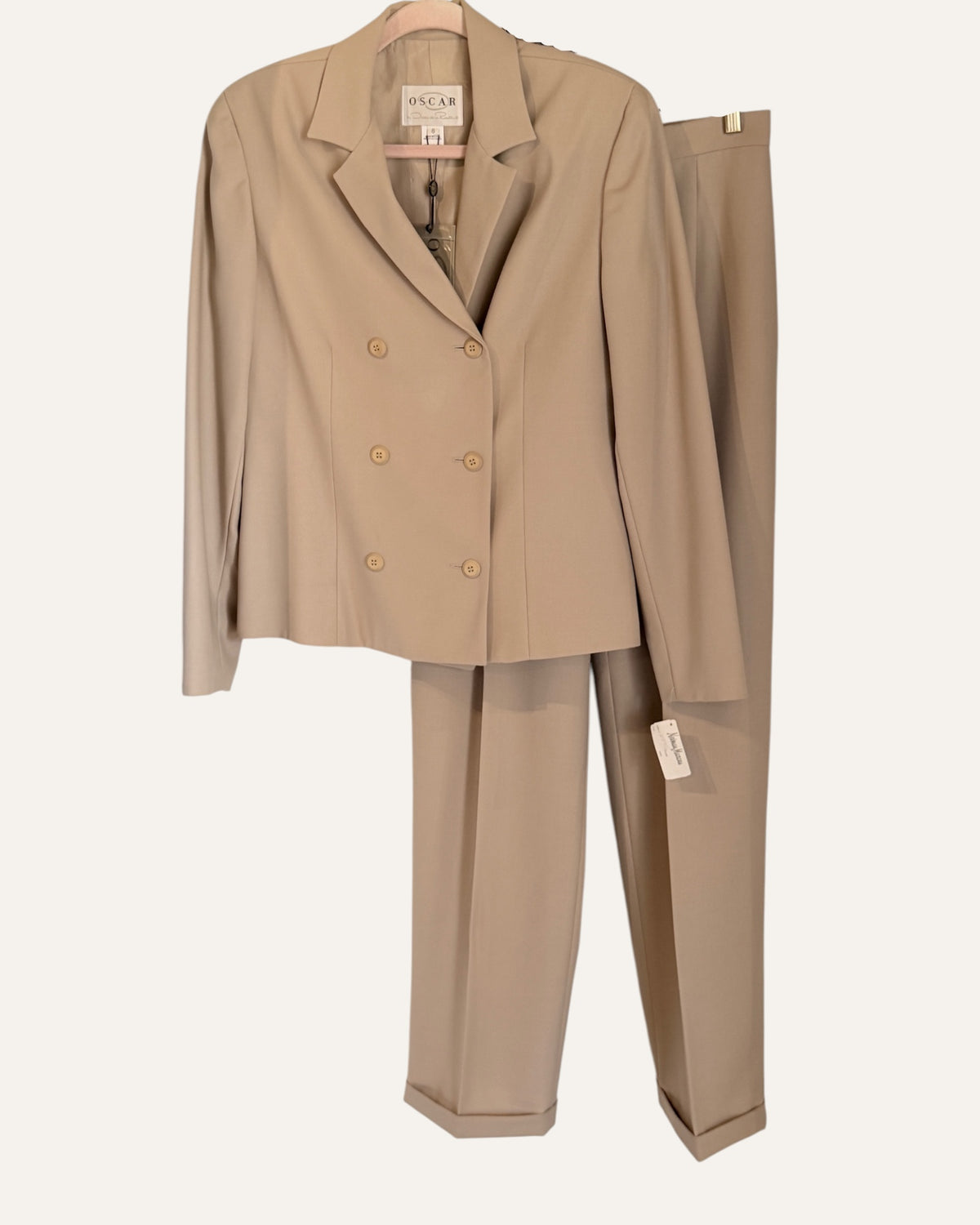 Oscar by Oscar de la Renta camel wool double-breasted blazer and pleated cuffed trousers with Neiman Marcus tags on cream background