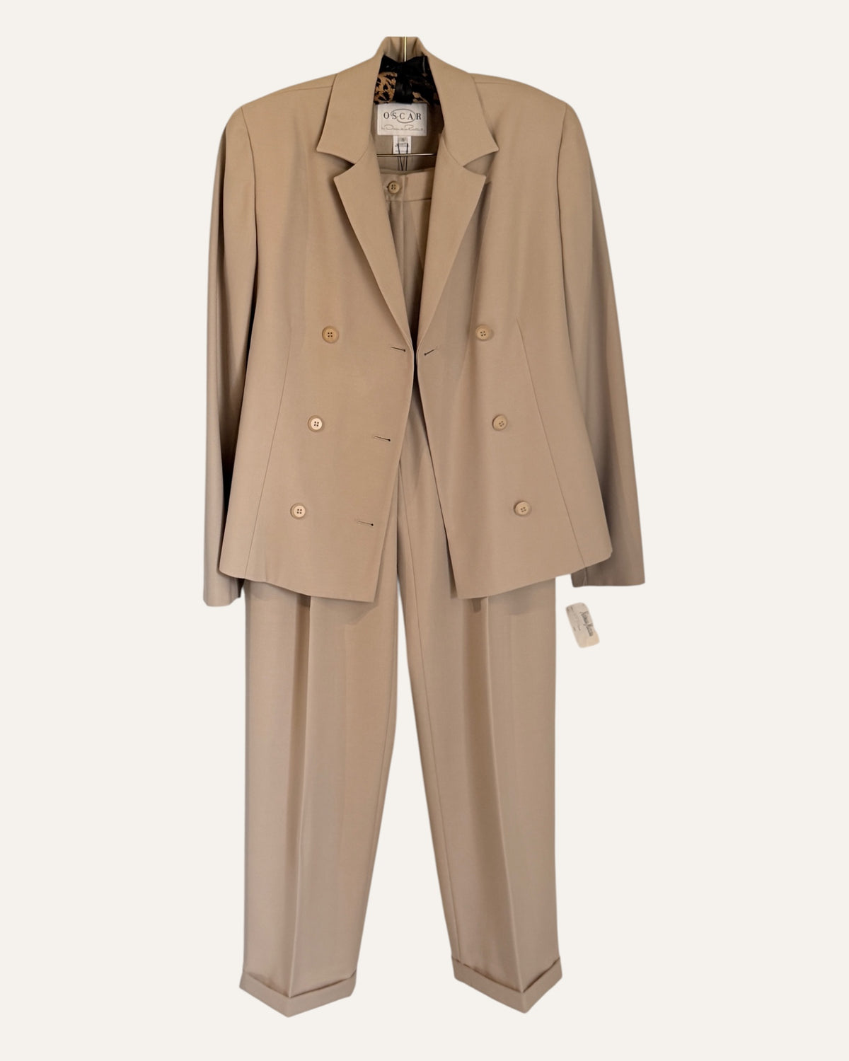Oscar by Oscar de la Renta camel wool double-breasted blazer and pleated cuffed trousers with Neiman Marcus tags on cream background