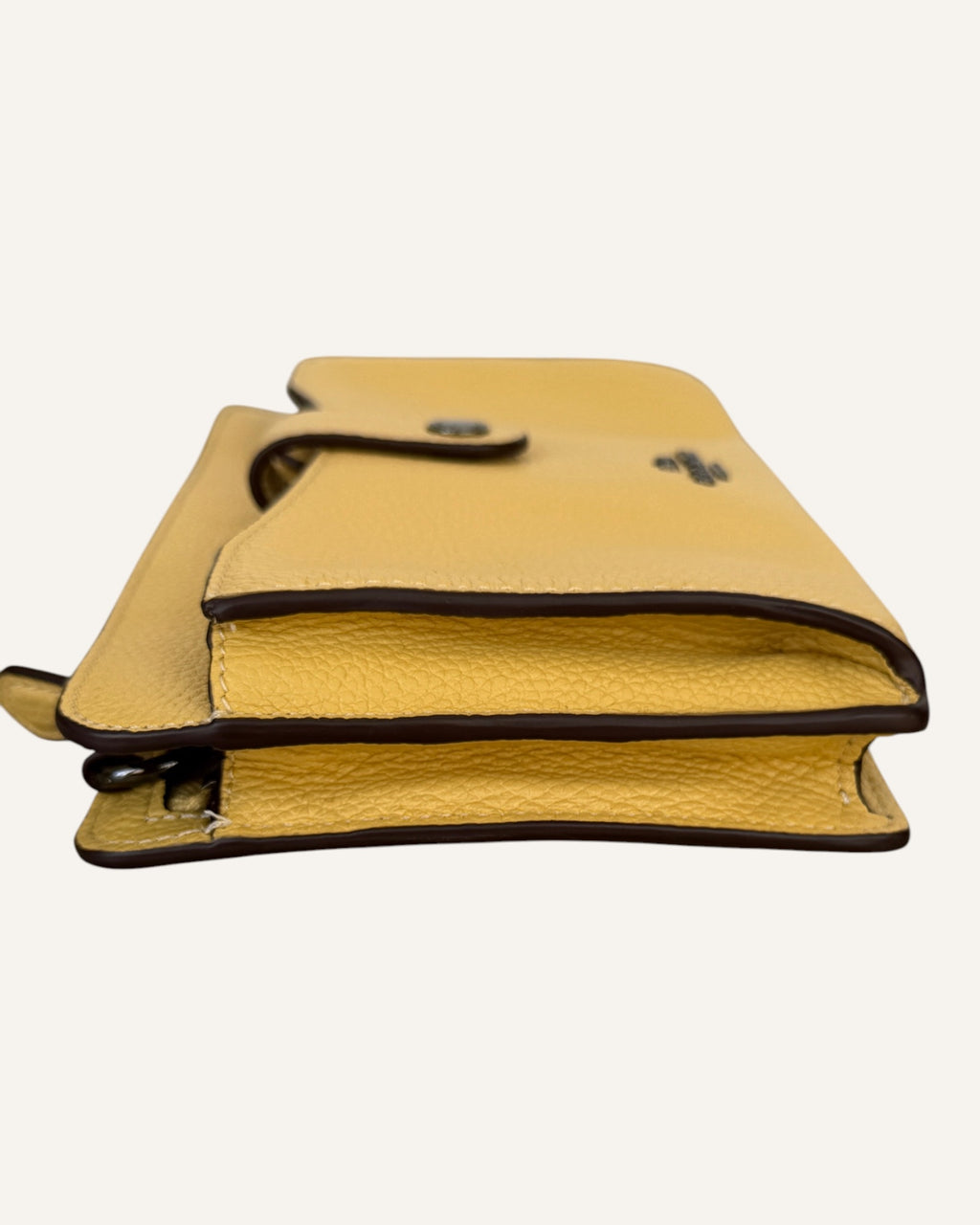 Coach mustard yellow pebbled leather wristlet wallet with snap-tab slip pocket and silver hardware