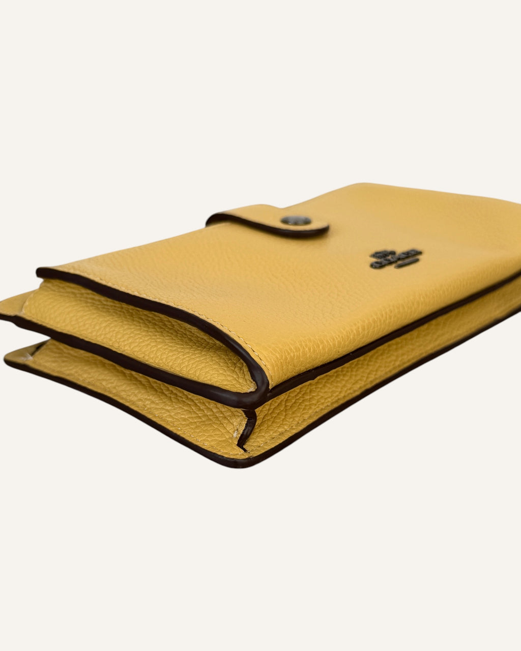 Coach mustard yellow pebbled leather wristlet wallet with snap-tab slip pocket and silver hardware