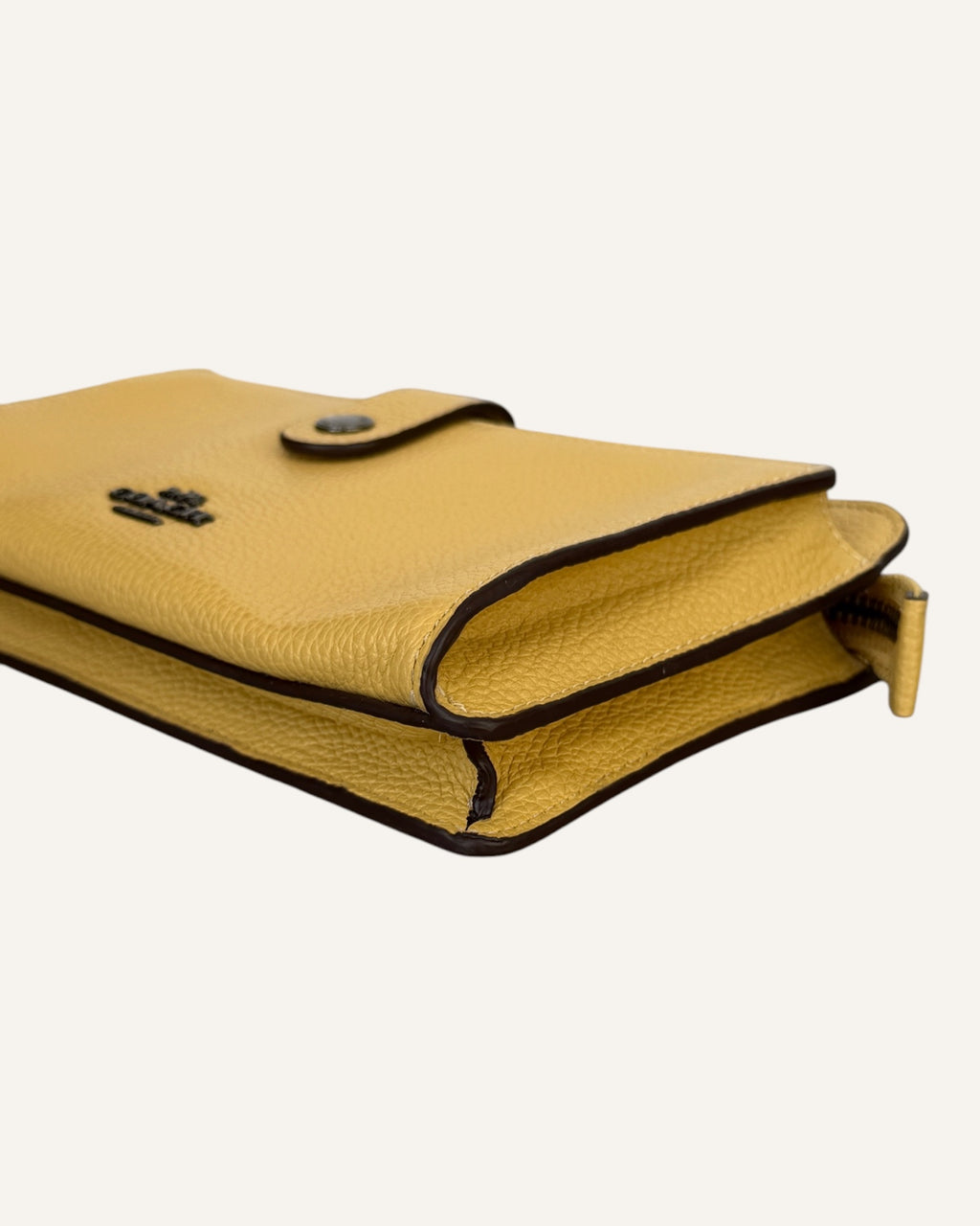 Coach mustard yellow pebbled leather wristlet wallet with snap-tab slip pocket and silver hardware