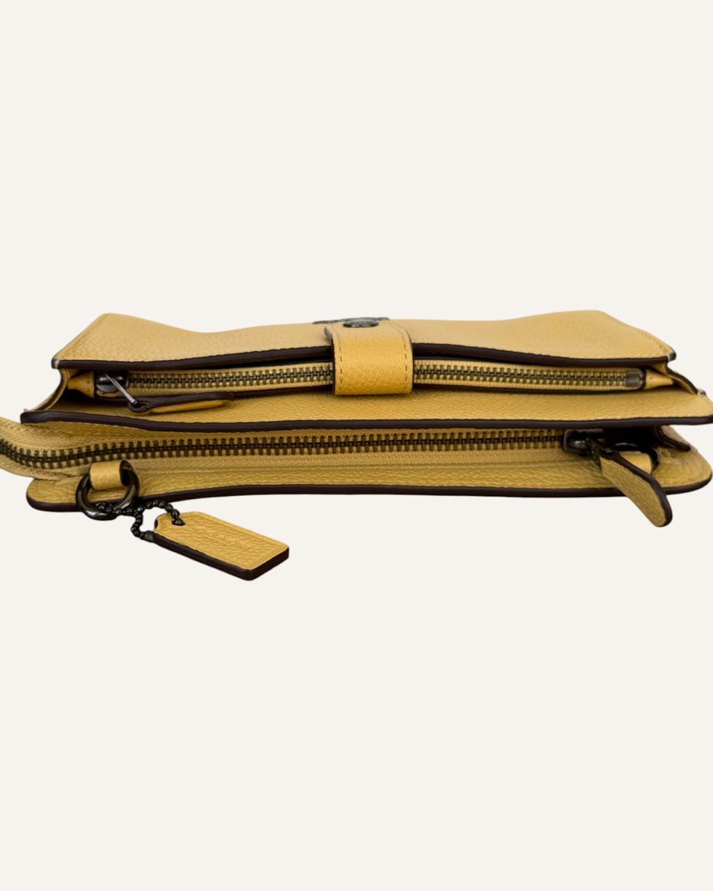 Coach mustard yellow pebbled leather wristlet wallet with snap-tab slip pocket and silver hardware