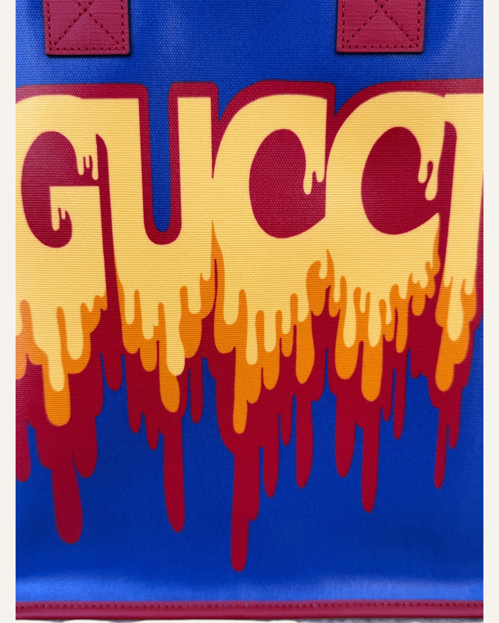 Gucci melting logo tote in royal blue coated canvas with red leather handles and yellow dripping logo print