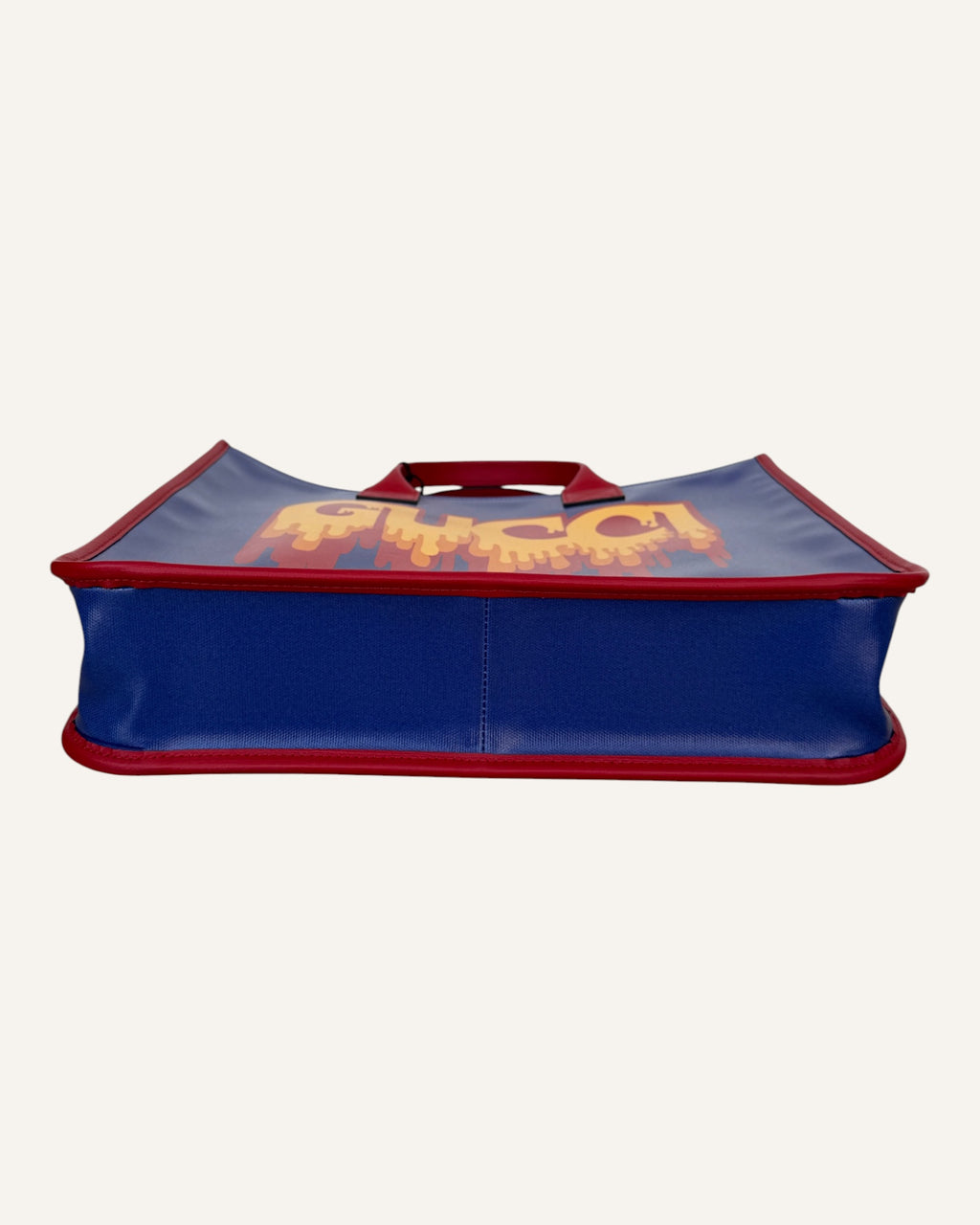 Gucci melting logo tote in royal blue coated canvas with red leather handles and yellow dripping logo print