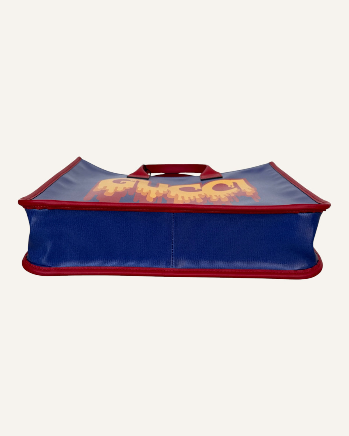 Gucci melting logo tote in royal blue coated canvas with red leather handles and yellow dripping logo print